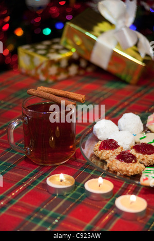 Nahaufnahme der hausgemachte Weihnachtskekse auf Glasplatte mit heißen gewürzten Apfelwein trinken aus seitlich angeordnet Stockfoto