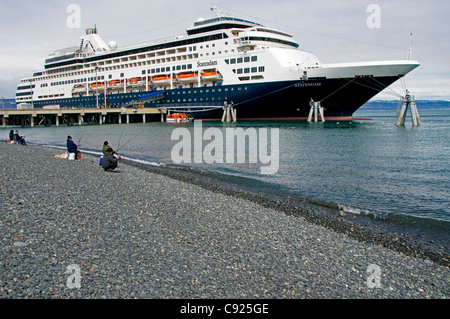 Ein Kreuzfahrtschiff angedockt auf den Homer Spit überragt Sportfischer am Strand Kachemak Bay, Homer Spit, Alaska, Frühling Stockfoto