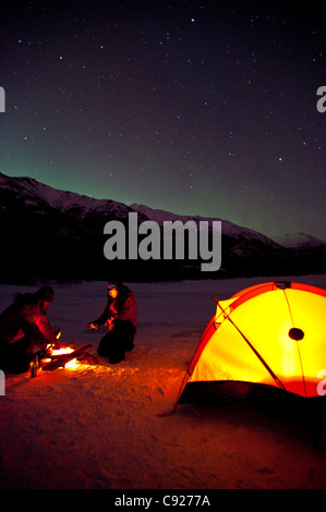 Zwei Männer-Camp auf dem zugefrorenen Eklutna-See mit dem Nordlicht-Overhead, Chugach State Park, Yunan Alaska, Winter Stockfoto