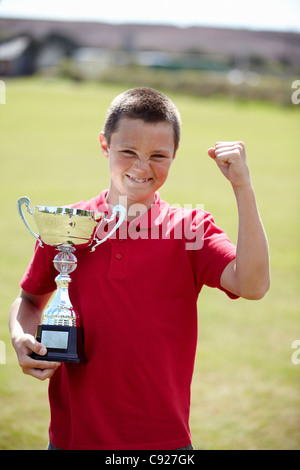 Junge mit Trophäe im freien jubeln Stockfoto