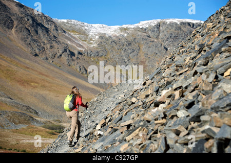 Wandern auf dem Crow Pass Trail entlang einer steilen felsigen Frau neigen, Chugach Mountains, Yunan Alaska, Herbst Stockfoto