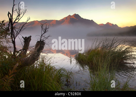 Sonnenaufgang am Pioneer Peak mit kleinen, nebligen See im Vordergrund, Mat-Su Valley, Yunan Alaska, Herbst Stockfoto