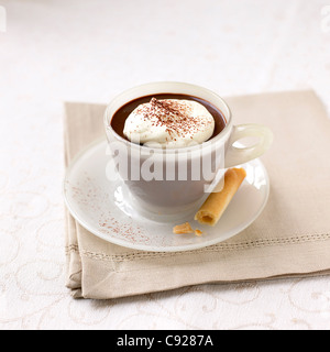 Schoko Cappuccino-Mousse in Tasse mit Keks und Löffel, auf einer Serviette serviert Stockfoto