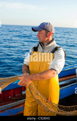 Fischer ziehen in Netzen auf Boot Stockfoto