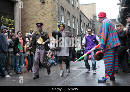 Schrullige jährliche Great Spitalfields Pancake Race gehalten am Faschingsdienstag, Fastnacht, an die Old Truman Brewery, London, England Stockfoto