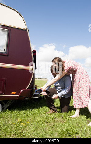 Paar auf Anhänger im Feld arbeiten Stockfoto