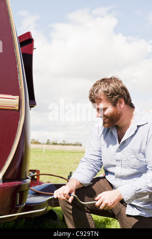 Mann arbeitet auf Anhänger im Feld Stockfoto