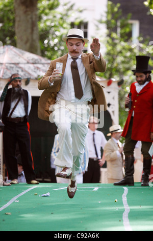 "Hop, Skip und G & T" bei der skurrilen jährliche Chap-Olympiade statt, im Sommer, Bedford Square Gardens in Bloomsbury, London, England Stockfoto