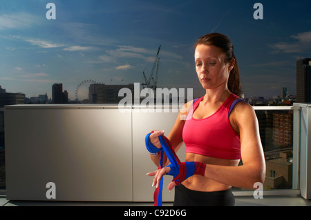 Boxer, die Hände auf städtischen Dach einwickeln Stockfoto
