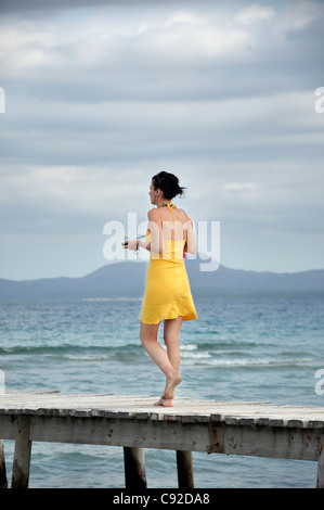 Junge Frau zu Fuß auf hölzerne pier Stockfoto