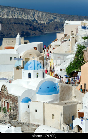 Blick auf die griechische Insel Santorini Dorf Oia mit seinem Mix aus blauen Kuppelkirchen, weiß getünchten Häusern und Pastellfarben. Stockfoto