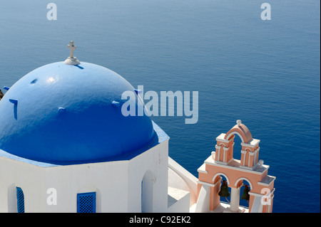 Blick auf die blaue Kuppel griechisch-orthodoxen Anastasis Kirche mit Blick auf das azurblaue Wasser des Santorini Caldera. Stockfoto