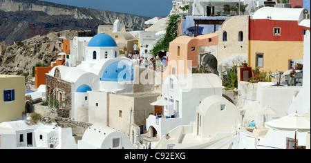 Blick auf den malerischen Santorini griechische Dorf Oia mit seinem Mix aus blauen Kuppelkirchen, weiß getünchten Häusern und Pastell-Farben Stockfoto