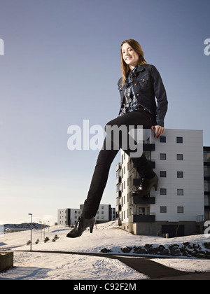 Übergroße Frau sitzt am Gebäude Stockfoto