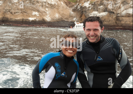 Glückliches Paar lächelnd in Neoprenanzüge, Kicker Rock, San Cristobal Insel, Galapagos-Inseln, Ecuador Stockfoto