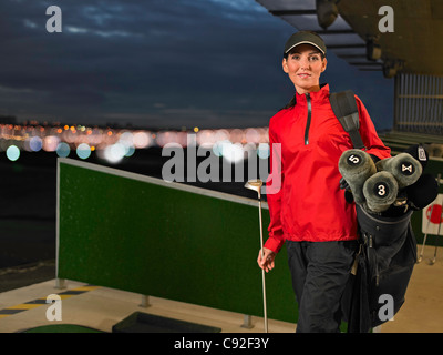 Frau mit Golf-Clubs auf der driving-range Stockfoto