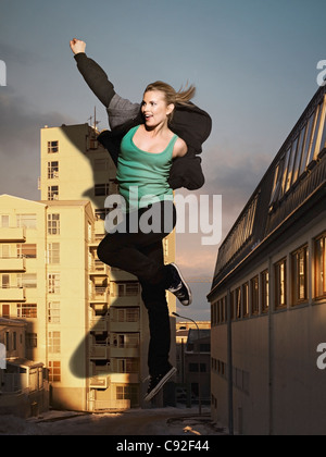 Übergroße Frau springen durch den Bau Stockfoto