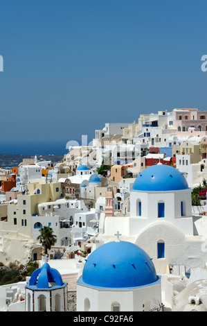 Blick auf die malerische Santorin Oia mit seinem Mix aus blauen Kuppelkirchen, weiß getünchten Häusern und Pastellfarben. Stockfoto