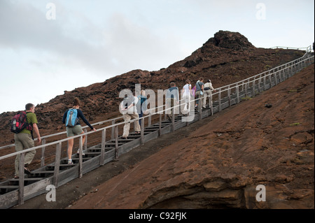 Touristen, die zu Fuß auf einem abgestuften Gehweg auf einer vulkanischen Landschaft, Bartolome Insel, Galapagos-Inseln, Ecuador Stockfoto