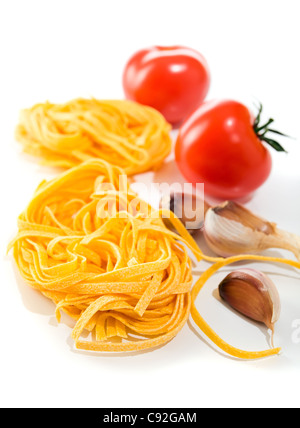 Zutaten: Nudeln, Tomaten und Knoblauch auf einem weißen Hintergrund. Stockfoto