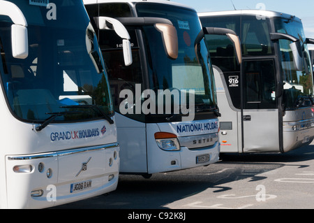Reisebusse, aufgereiht auf einem Busparkplatz an eine touristische Attraktion. Stockfoto