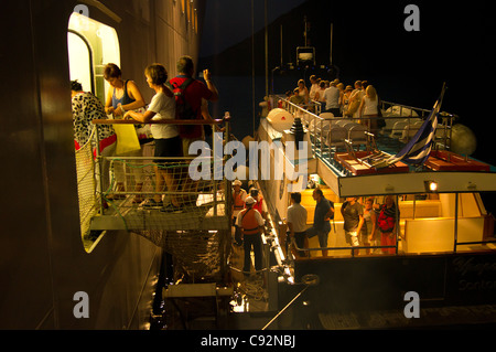 Santorini - ein Shuttleboot Touristen kehrt das Kreuzfahrtschiff MSC Armonia, nach Einbruch der Dunkelheit - wieder einschiffen. Stockfoto