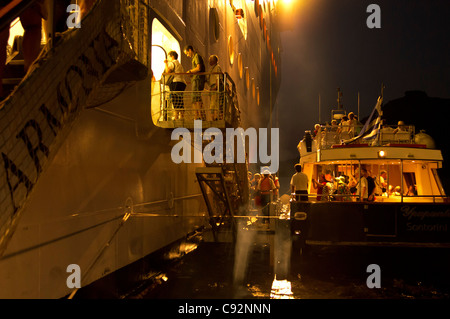 Santorini - ein Shuttleboot Touristen kehrt das Kreuzfahrtschiff MSC Armonia, nach Einbruch der Dunkelheit - wieder einschiffen. Stockfoto