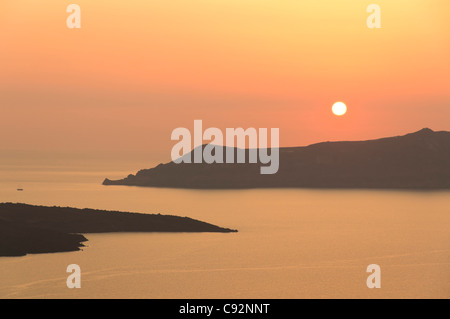 Santorini - Sonnenuntergang von Fira entfernt über die Inseln von den Vulkankrater. Inseln von Nea Kameni und Therasia links und rechts. Stockfoto