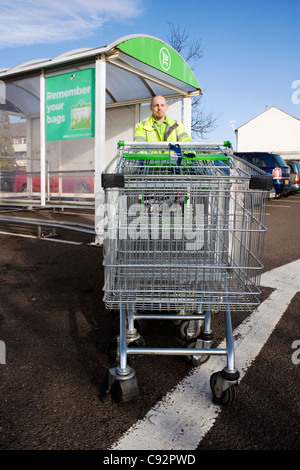 Mann arbeitet in einem Supermarkt Einkaufswagen schieben Stockfoto