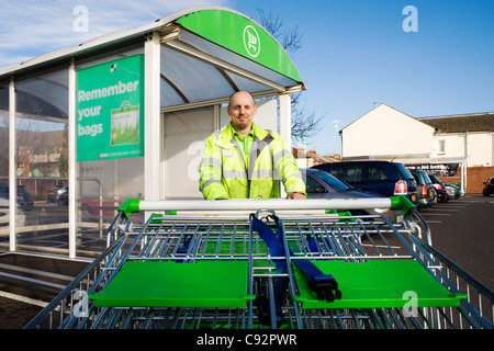 Mann arbeitet in einem Supermarkt Einkaufswagen schieben Stockfoto