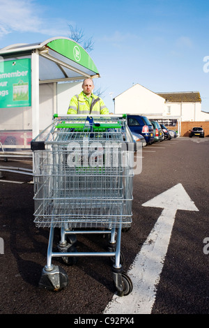 Mann arbeitet in einem Supermarkt Einkaufswagen schieben Stockfoto