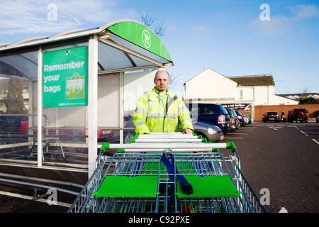 Mann arbeitet in einem Supermarkt Einkaufswagen schieben Stockfoto