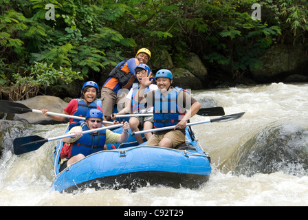 Personen mit Schutzausrüstung (Helme, Rettungswesten), die in Schlauchbooten, Citarik River, West Java, Indonesien, Stromschnellen abfahren Stockfoto