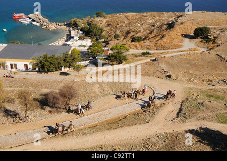 Blick hinunter auf die Bucht bei Lindos mit Eseln bringt Touristen bis zu der Akropolis Stockfoto