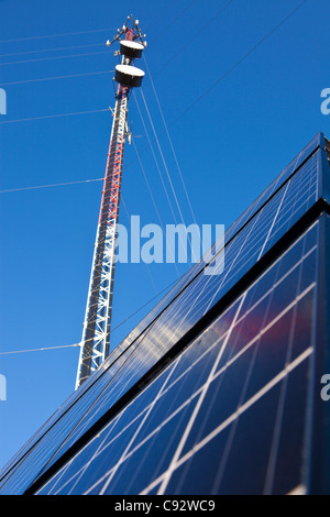 Abgespannte Sendemast mit Sonnenkollektoren installiert auf dem Boden Stockfoto