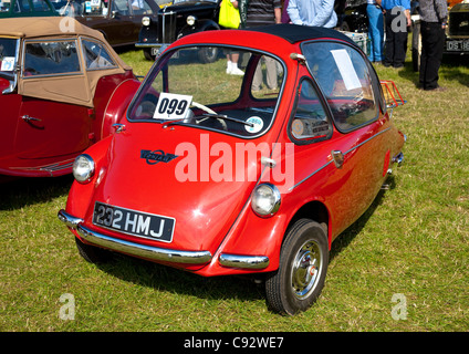 roten Dreirad Trojan Bubble Auto mit anderen Oldtimer bei einer Show mit Menschen zu Fuß und bewundern Stockfoto