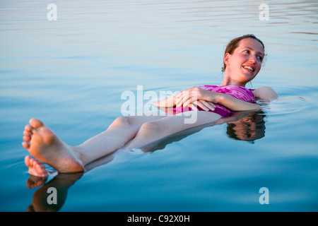 Frau Tourist / Mädchen flott floating / a auf das hohe Salz Inhalte / salzig salzhaltige Wasser des Toten Meeres Sees schweben. Stockfoto