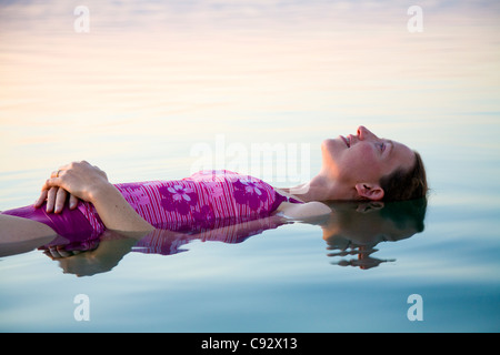 Frau Tourist / Mädchen flott floating / a auf das hohe Salz Inhalte / salzig salzhaltige Wasser des Toten Meeres Sees schweben. Stockfoto