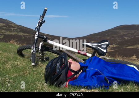 Eine junge Frau, die Entspannung durch ihr Mountainbike auf der Überfahrt von Skiddaw im Lake District Stockfoto