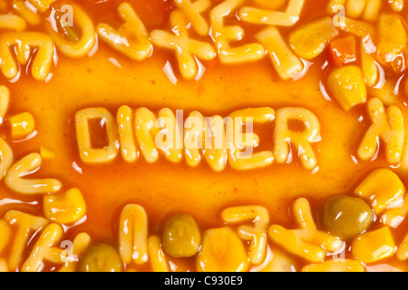 Alphabet geformten Nudeln bilden das Wort Abendessen in Tomatensauce Stockfoto