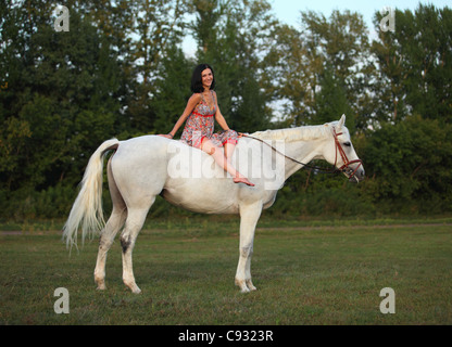 Junge Frau Reiter und ihr Pferd herein Abend Weide Stockfoto