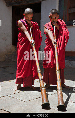 Zwei Mönche wehen lange Hörner, Kot-Chen, in Wangdue Phodrang Dzong (Festung) genannt. Stockfoto