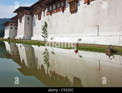 Ein junger Mönch Spaziergänge entlang der Außenwand der Punakha Dzong, ist die zweite älteste und größte Dzong in Bhutan. Stockfoto