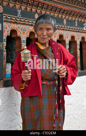 Eine fromme Buddhist Frau dreht sich ihr Handheld Gebetsmühle in Punakha Dzong, ist die zweite älteste und größte Dzong in Bhutan. Stockfoto