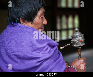 Eine Frau dreht ihr Handheld Gebetsmühle im Changangkha Tempel am Stadtrand von Thimphu. Stockfoto