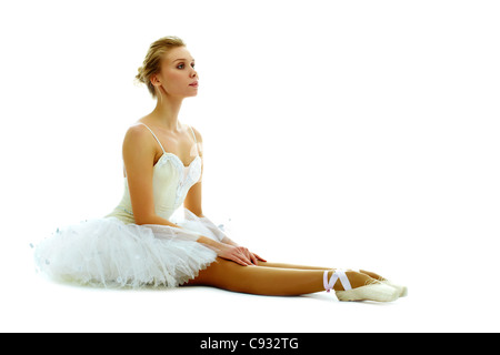 Porträt der anmutige Ballerina sitzen mit gestreckten Beinen auf weißem Hintergrund Stockfoto