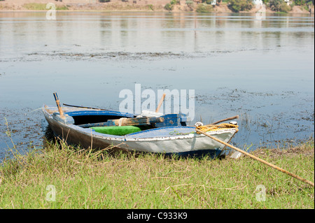 Alte hölzerne Ruderboot festgemacht an einem Flussufer Stockfoto