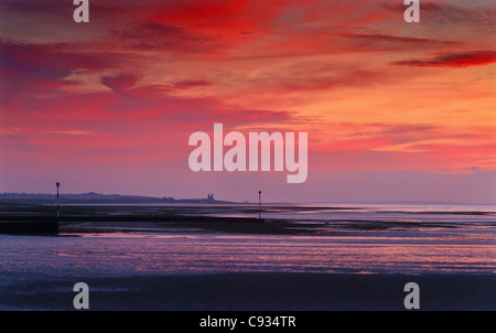 Roter Himmel über reculver Towers, Kent, England, bei Sonnenuntergang. Stockfoto