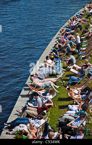 Touristen sitzen in Liegestühlen am Ufer der Spree in der Hauptstadt Strand Strandbar, Tiergarten, Berlin, Deutschland Stockfoto