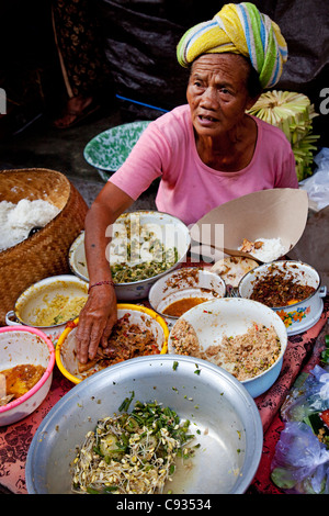 Bali Ubud. Eine Dame serviert traditionelle balinesische Speisen zum Frühstück auf einem Markt in Ubud. Stockfoto